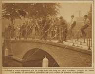 871266 Afbeelding van een groep jongens, die aan het vissen is vanaf een brug op een onbekende locatie te Utrecht.